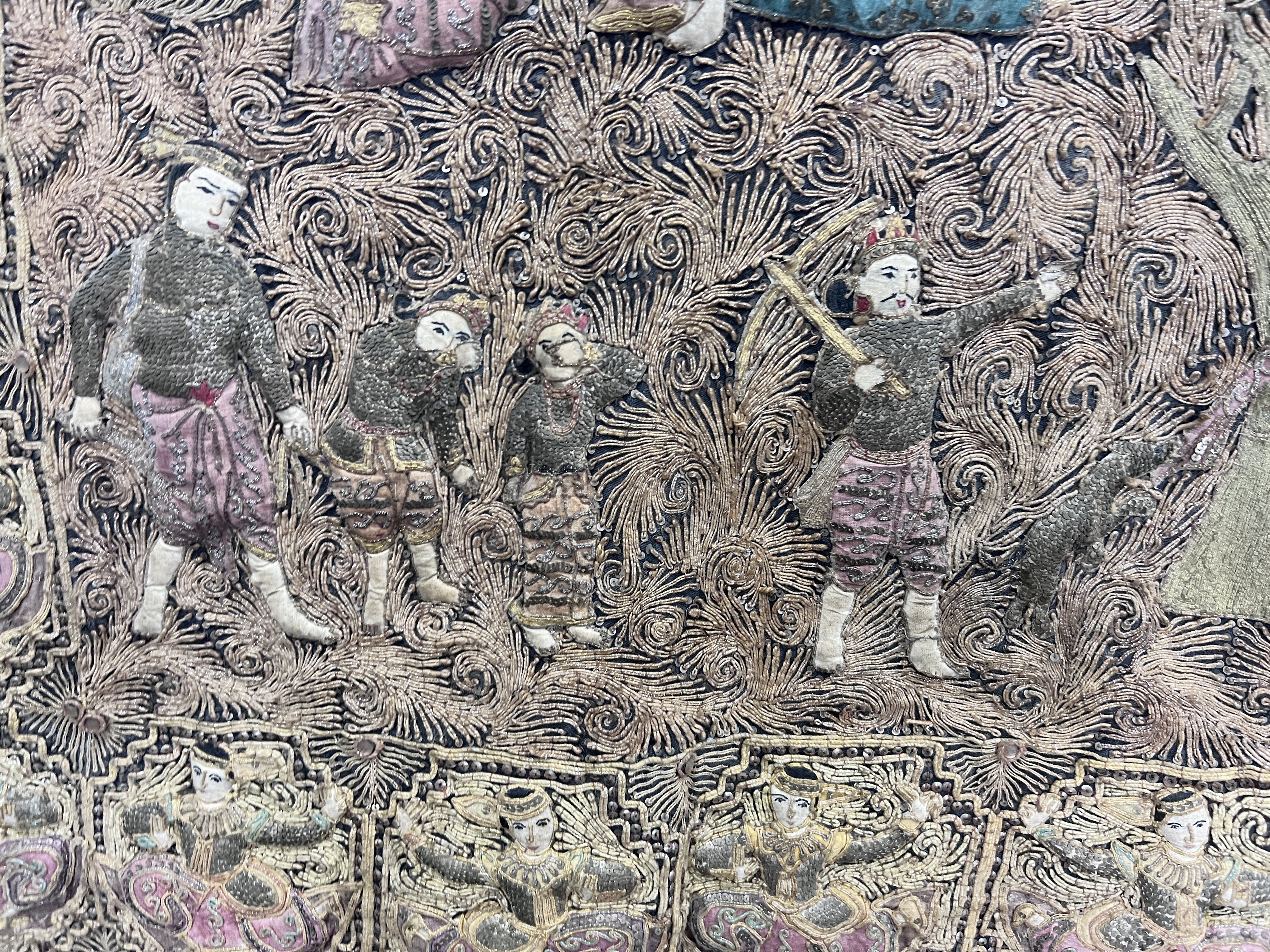 An Indian bullion work embroidered wall panel, depicting figures in a forest, width 124cm, height 90cm